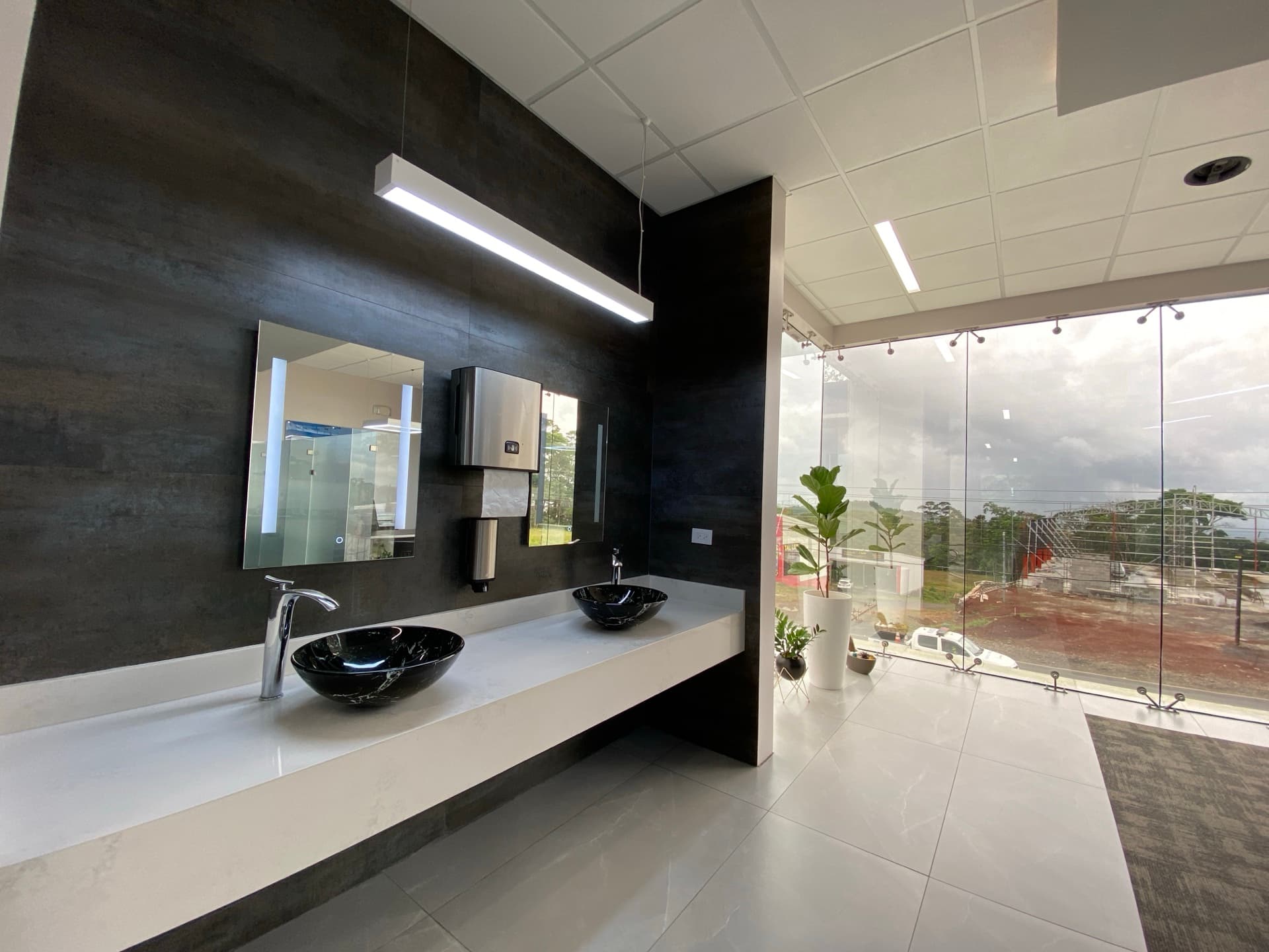Upscale patient restroom with black marble vessel sinks and panoramic windows