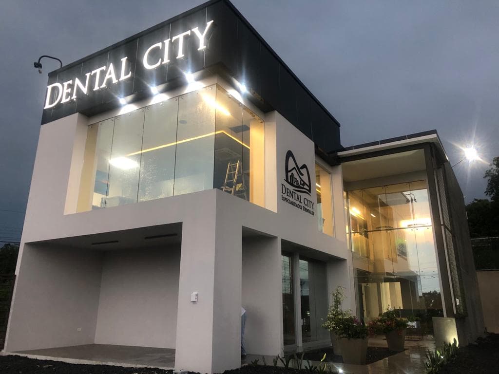 Dental City building exterior at night with illuminated signage