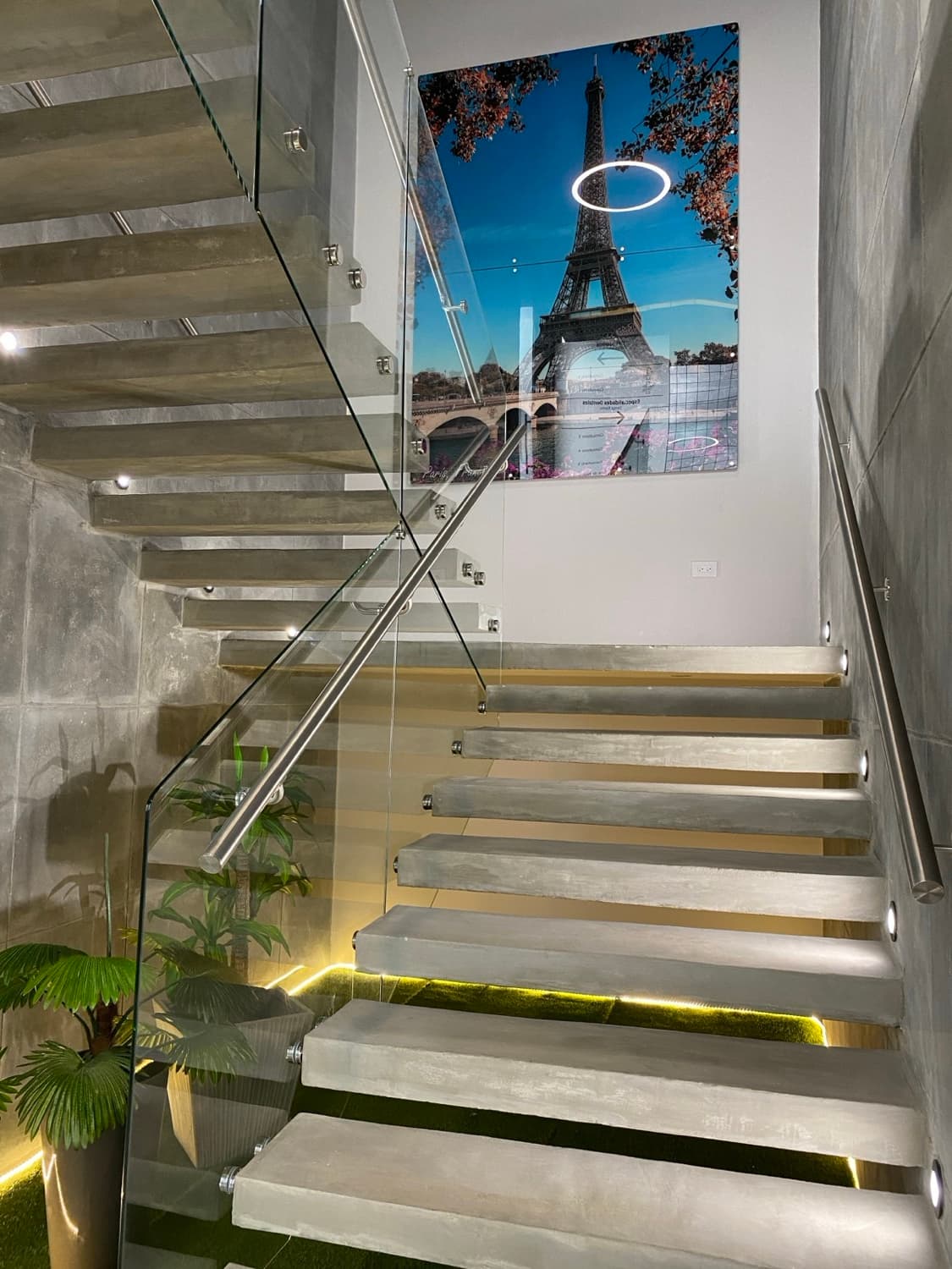 Upper staircase with Eiffel Tower art and modern concrete columns
